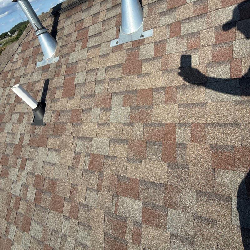 Asphalt shingle roof with ventilation pipe and storm damage