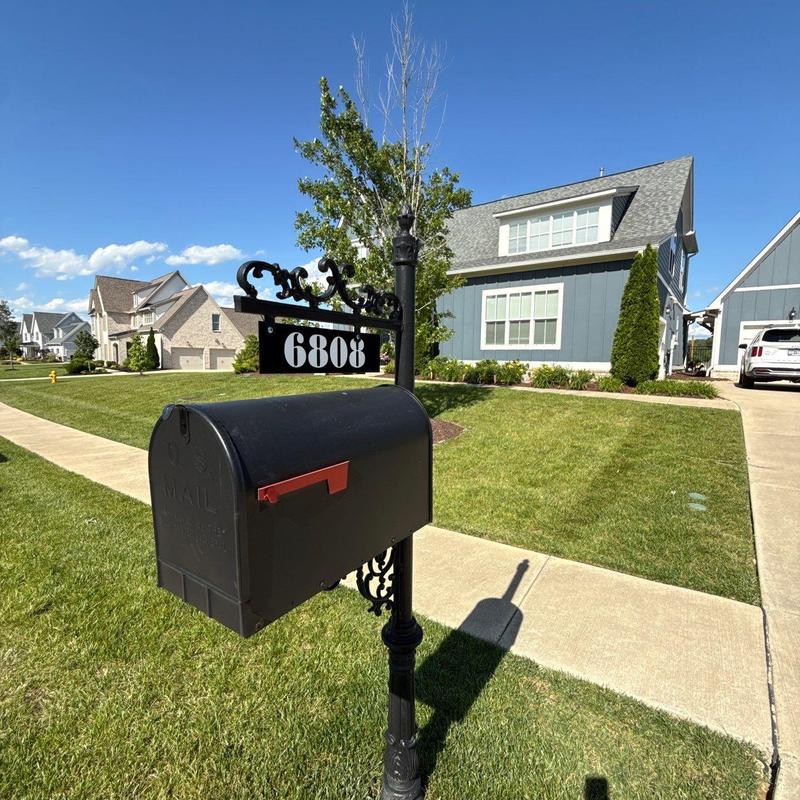 Mailbox post and black mailbox with house number