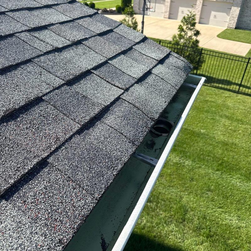 Asphalt shingle roof with hail damage near gutter edge