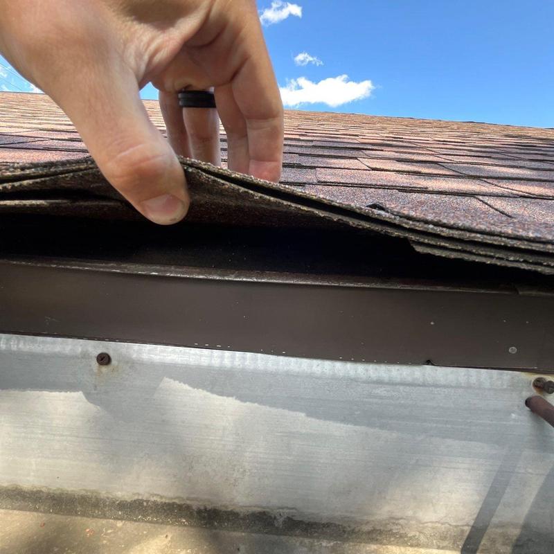 Asphalt shingles lifted showing possible hail damage inspection