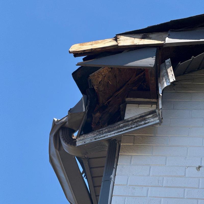 Gutter and fascia board damage with exposed wood decay