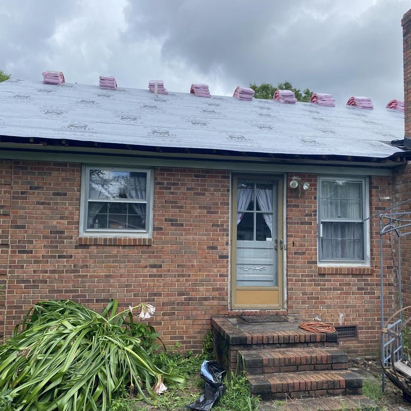 Roof underlayment with bundled shingles on brick house Roof underlayment with bundled shingles on brick house