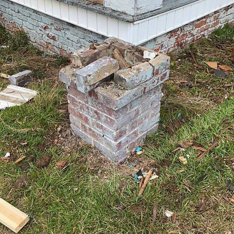Brick porch column with damaged top in yard