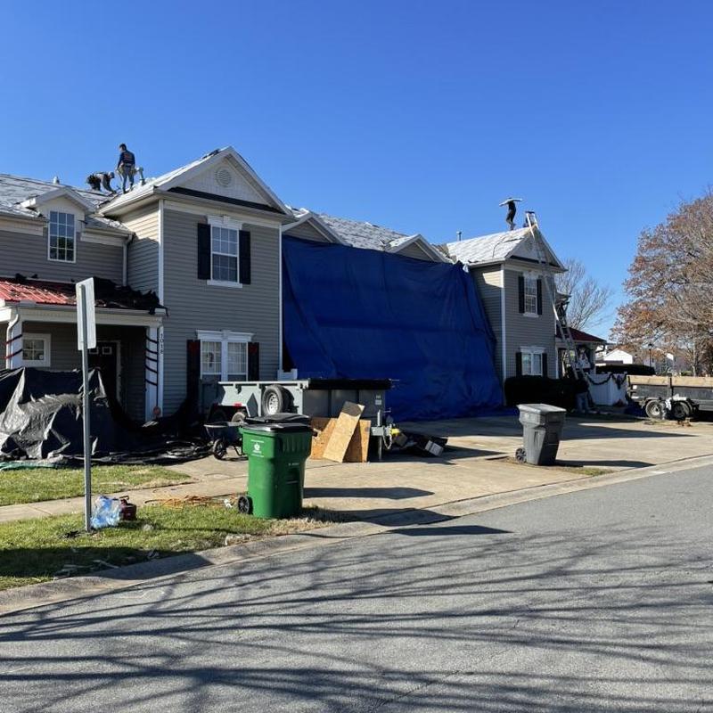 Asphalt shingle roofing with blue tarp covering Asphalt shingle roofing with blue tarp covering