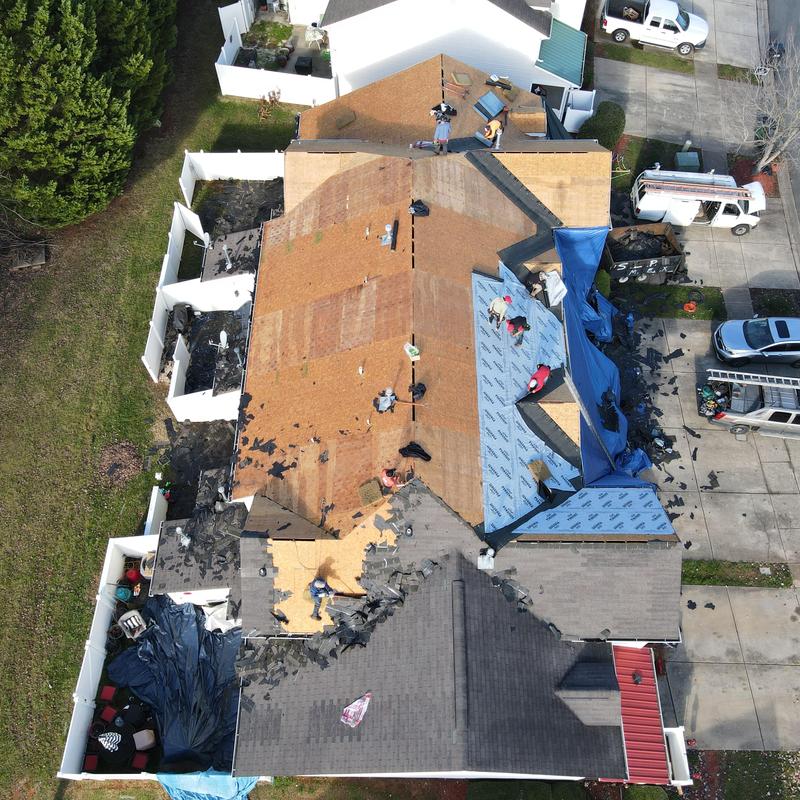 Residential shingle roof hail damage and replacement in progress Residential shingle roof hail damage and replacement in progress