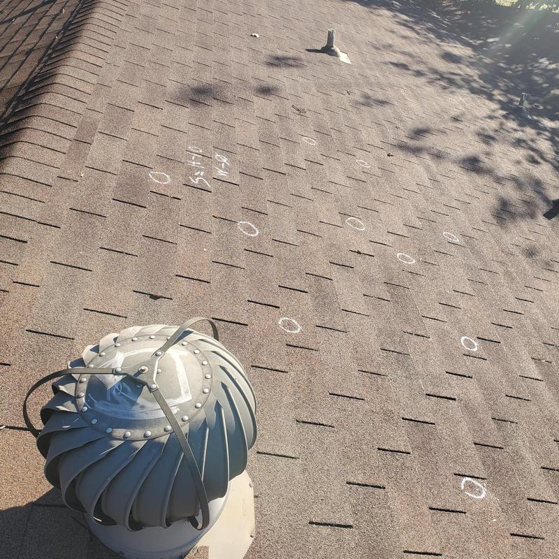 Asphalt shingle roof hail damage marked with chalk circles
