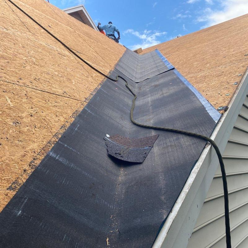 Roof valley underlayment installation with worker above Roof valley underlayment installation with worker above