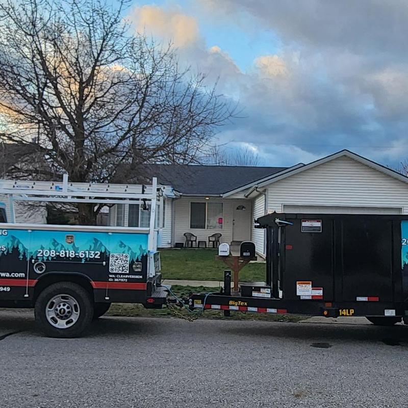 Asphalt shingle roof replacement with contractor truck and trailer