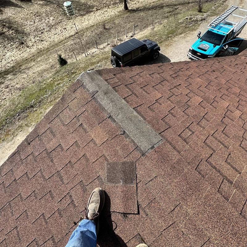 Asphalt shingle roof with damaged shingles and ridge repair