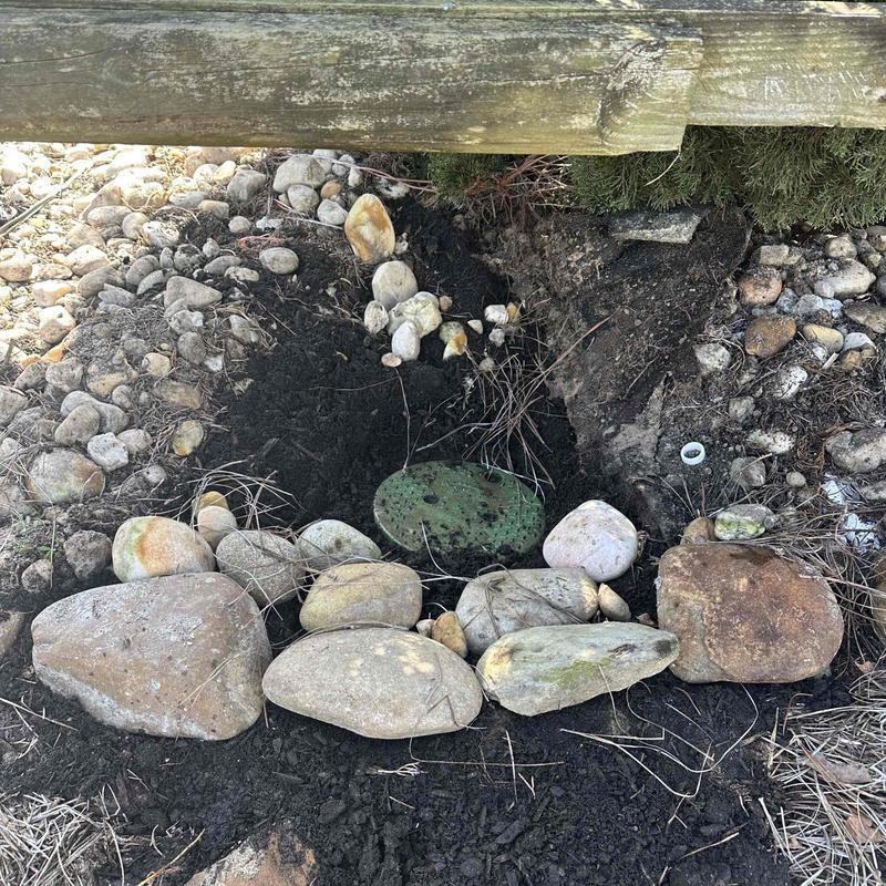 Underground water pipe exposed with rocks and soil Underground water pipe exposed with rocks and soil