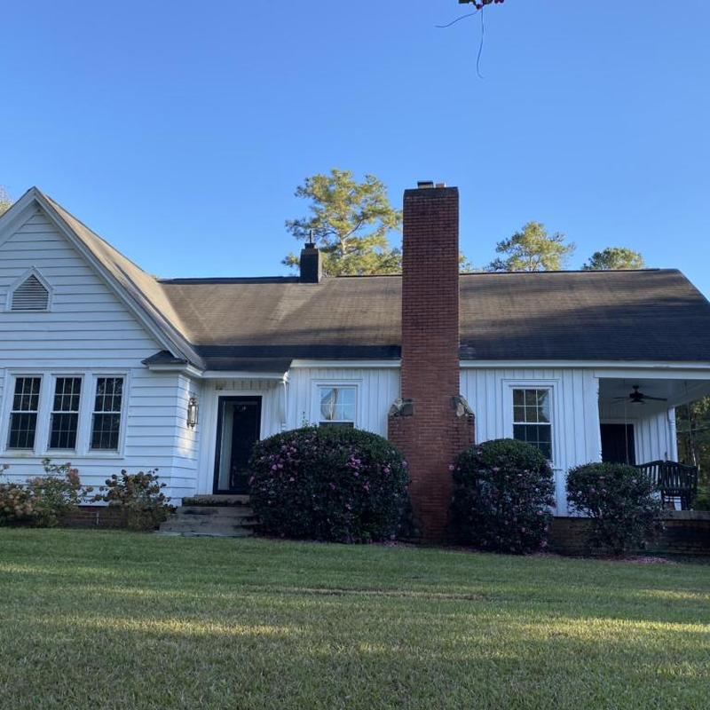 Asphalt shingle roof with chimney and white siding