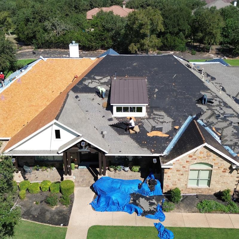Asphalt roofing installation with workers and materials Asphalt roofing installation with workers and materials