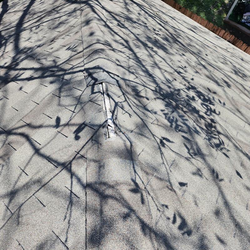 Hip shingles with wind damage on roof in Pflugerville