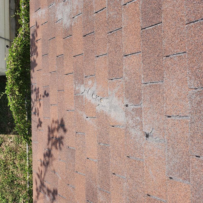 Asphalt shingle roof with worn and damaged area Asphalt shingle roof with worn and damaged area