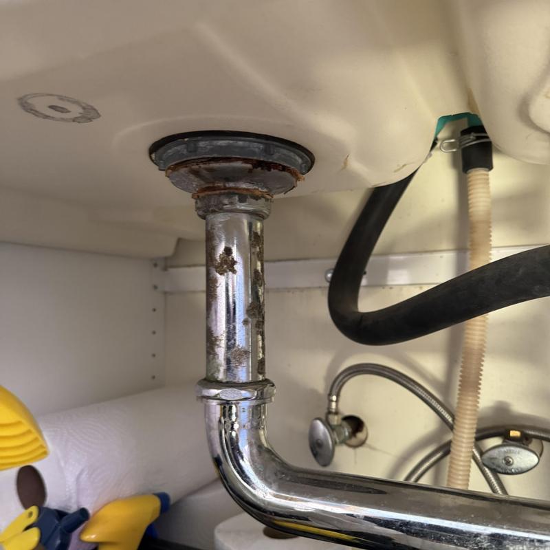 Sink drain pipe under kitchen cabinet with corrosion