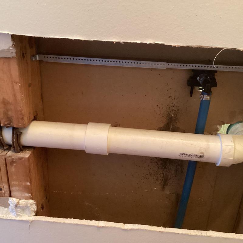 PVC drain and PEX supply lines inside wall cavity