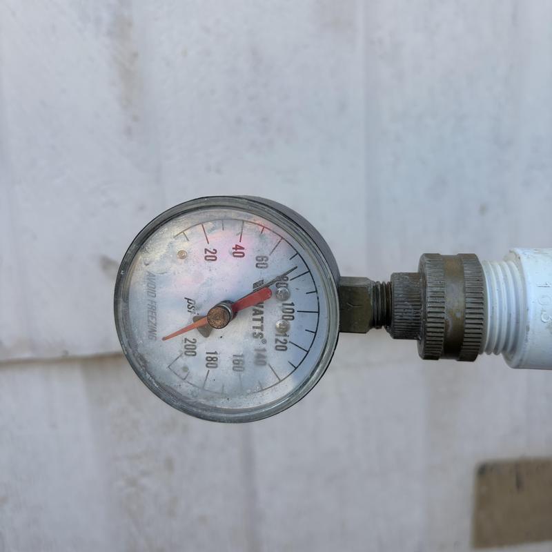 Water pressure gauge on outdoor pipe fitting