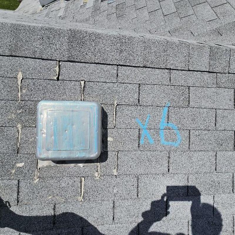 Roof shingles with hail damage marks and vent cover Roof shingles with hail damage marks and vent cover