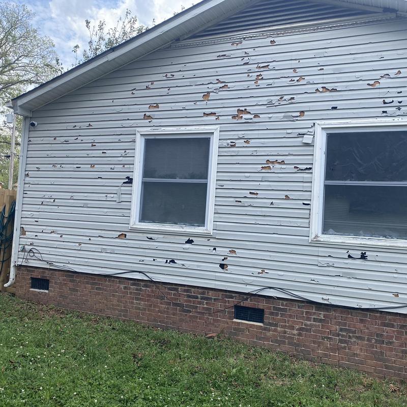 Vinyl siding hail damage on residential home exterior Vinyl siding hail damage on residential home exterior