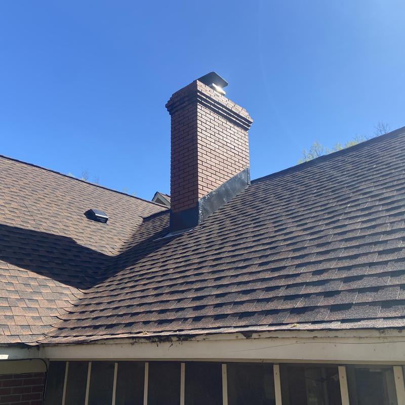 Architect roof shingles and brick chimney with flashing