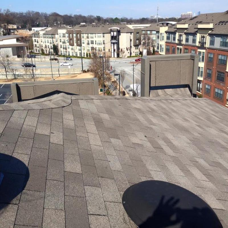 Asphalt shingle apartment roof with city background