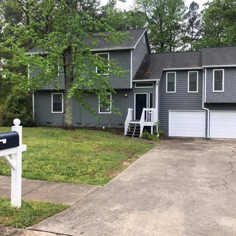 Asphalt shingle roof on gray two-story home