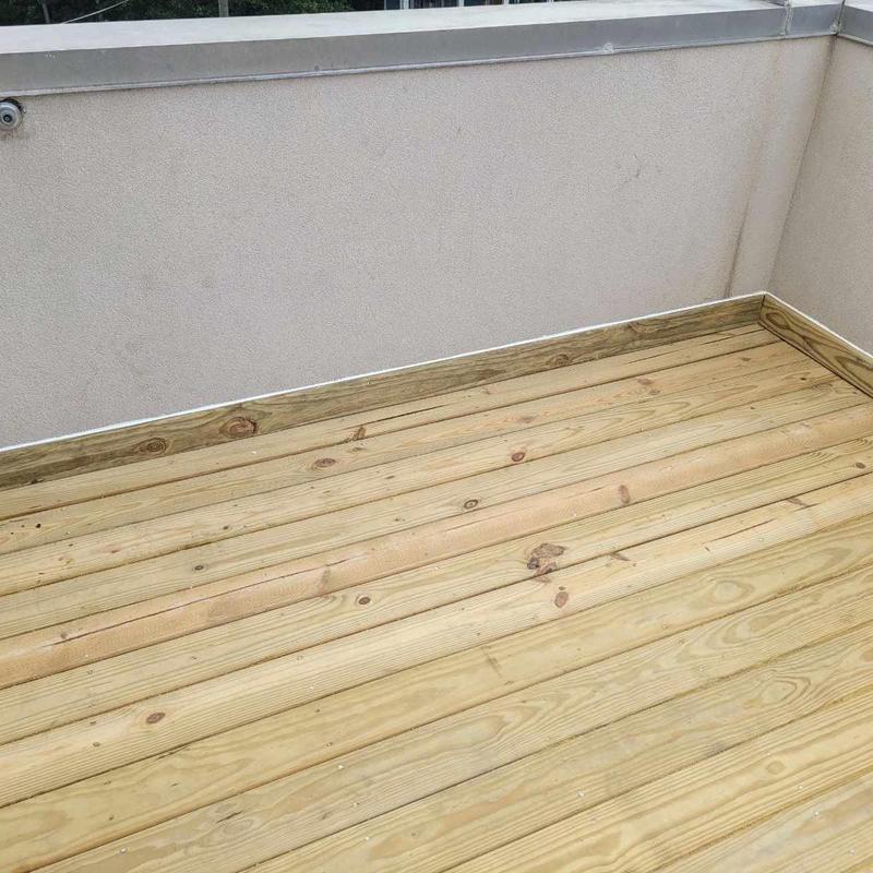 Wooden deck boards on flat rooftop installation