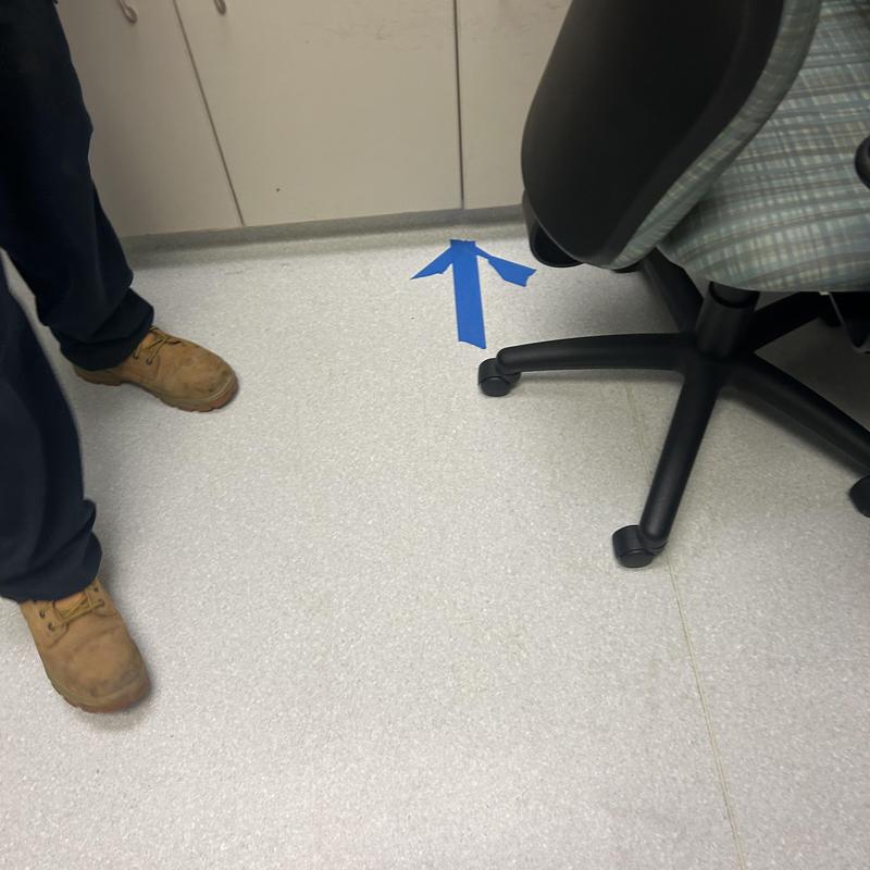 Main line pipe marked on floor with blue tape arrow Main line pipe marked on floor with blue tape arrow