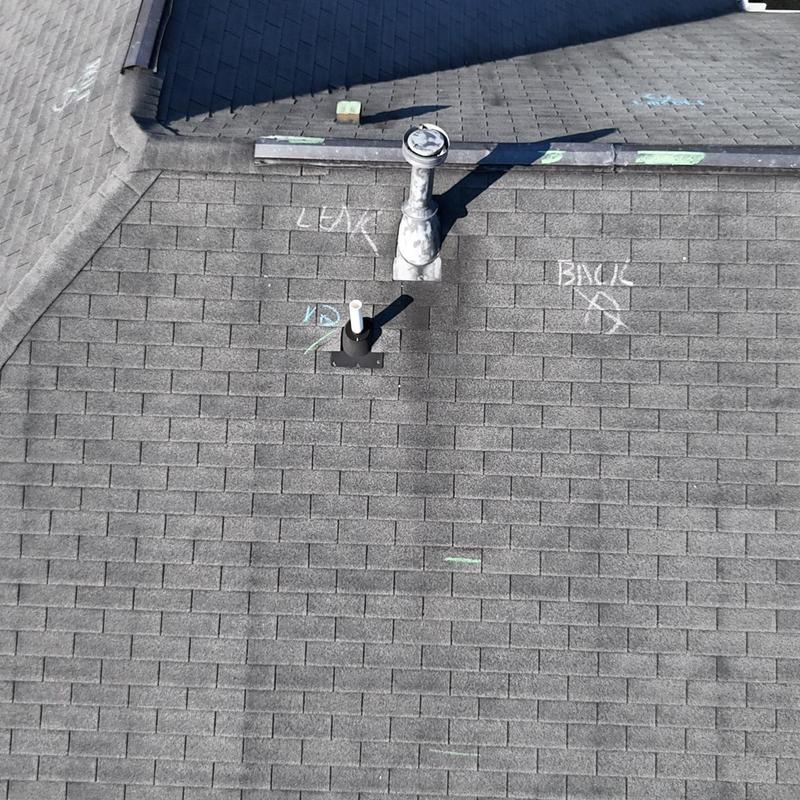 Asphalt shingles with leak markings and vent pipes