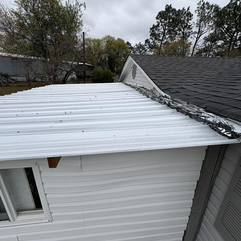 Metal porch roof with damaged flashing and panels