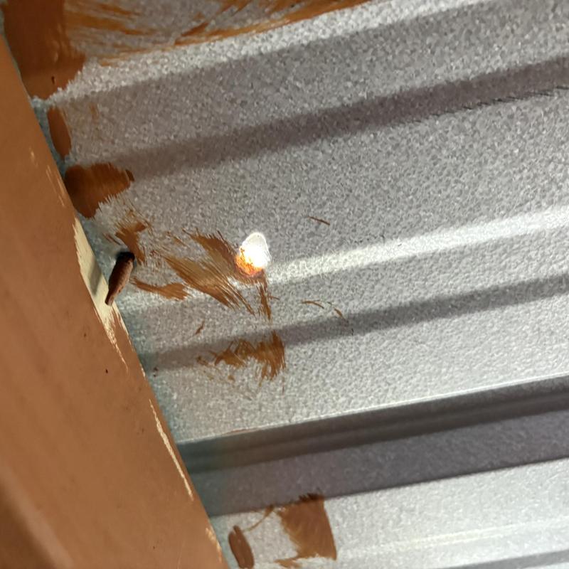 Metal porch roof with leak and rust damage