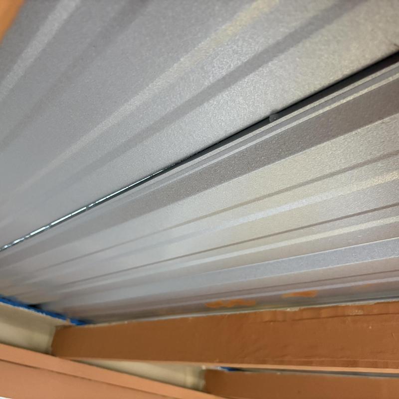 Metal porch roof panels with visible gaps and framing issues