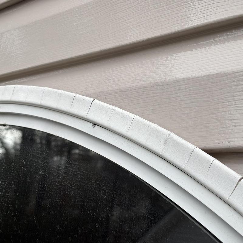 Window frame with cracked caulking on siding