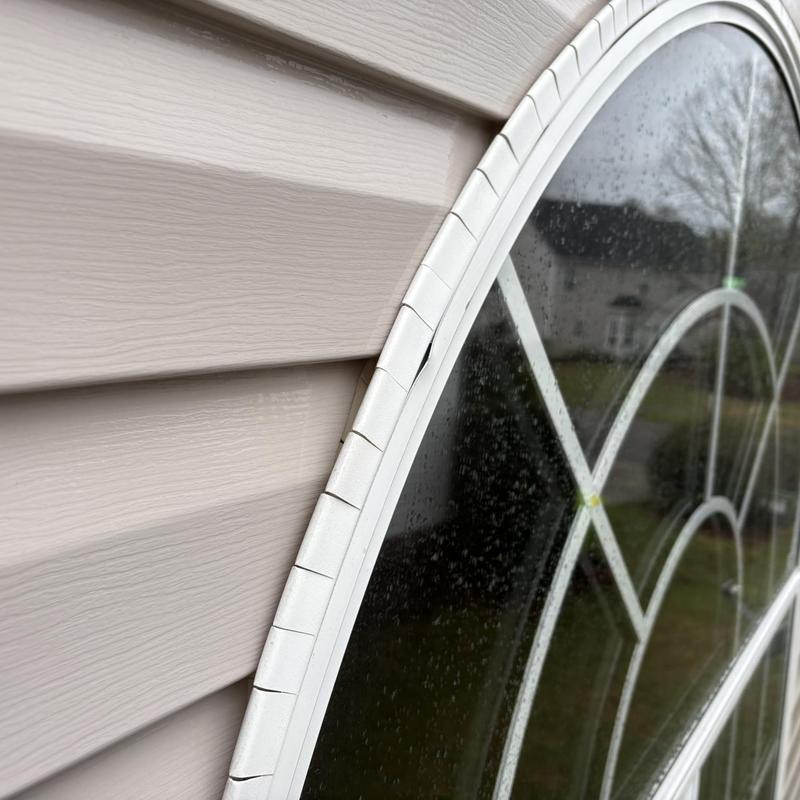 Window frame with cracked exterior sealant and siding