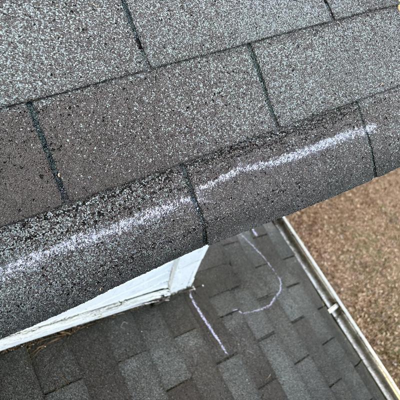 Roof shingles with chalk-marked damage line
