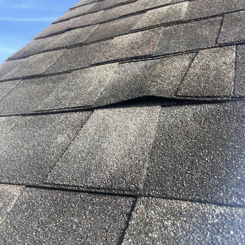 Shingle roof with lifted and loose shingles detail