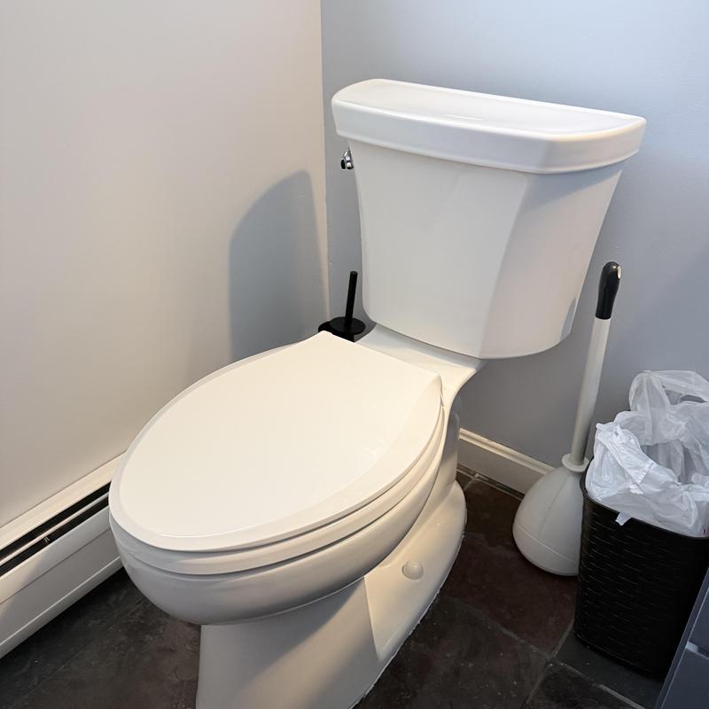 Kohler toilet with closed lid in bathroom corner Kohler toilet with closed lid in bathroom corner