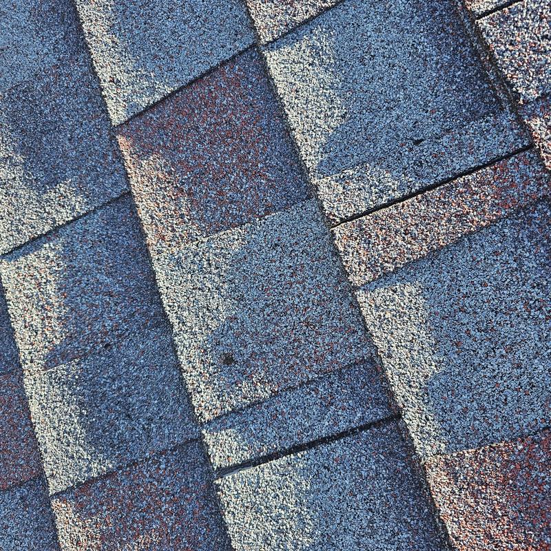 Asphalt shingles with visible hail damage close-up