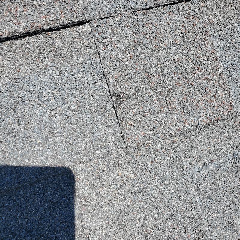 Asphalt shingle roof with visible hail damage spots
