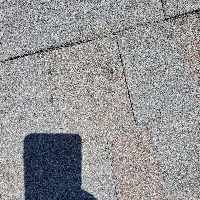 Asphalt shingle roof with hail damage close-up