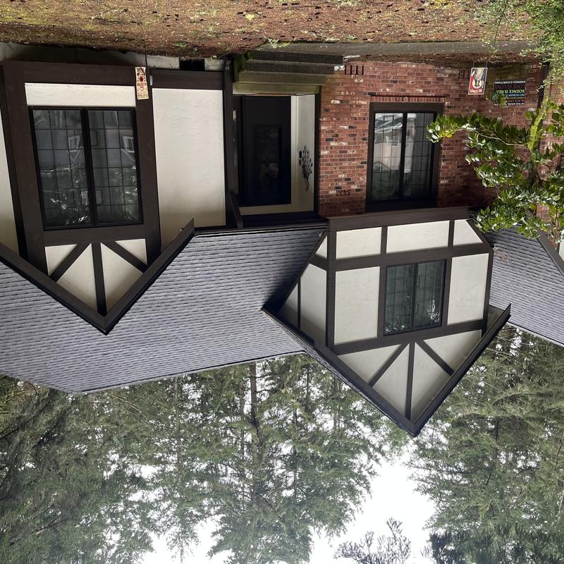 Gutters with clogged guards on wooded home exterior