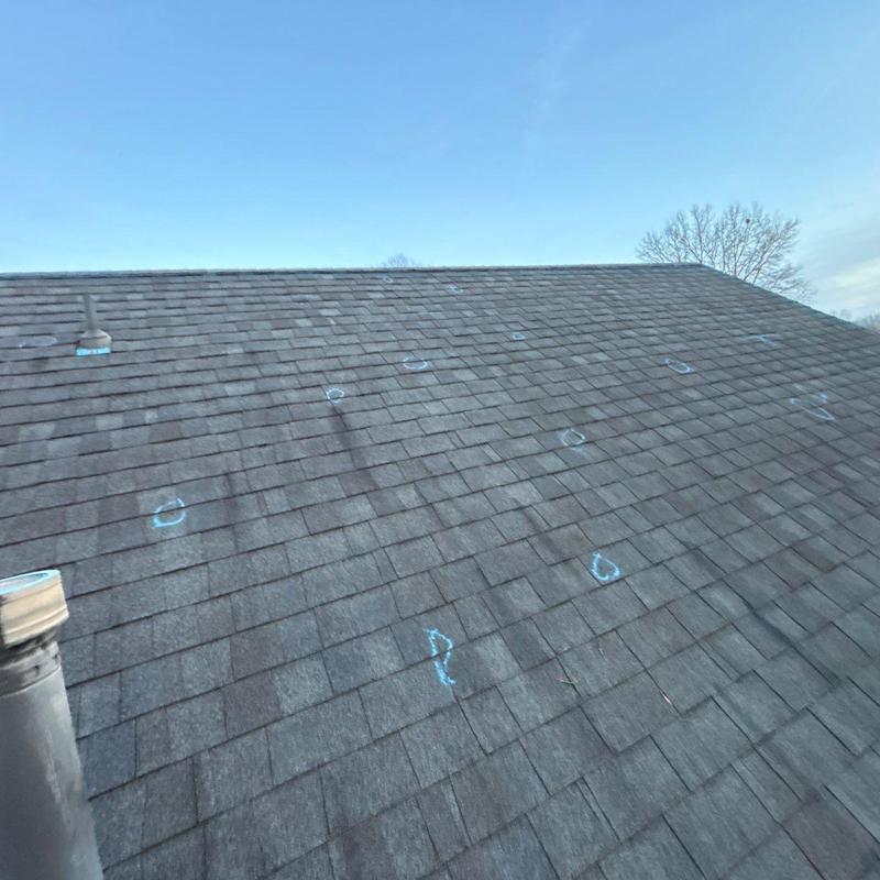 Asphalt roof with storm damage marked for inspection