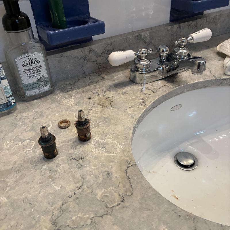 Basin faucet with removed hot and cold stems on countertop