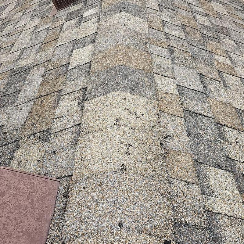 Asphalt shingle roof with visible hail damage spots Asphalt shingle roof with visible hail damage spots