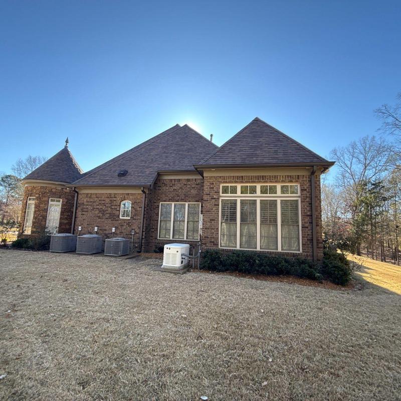 Asphalt shingle roof on brick home in sunny yard