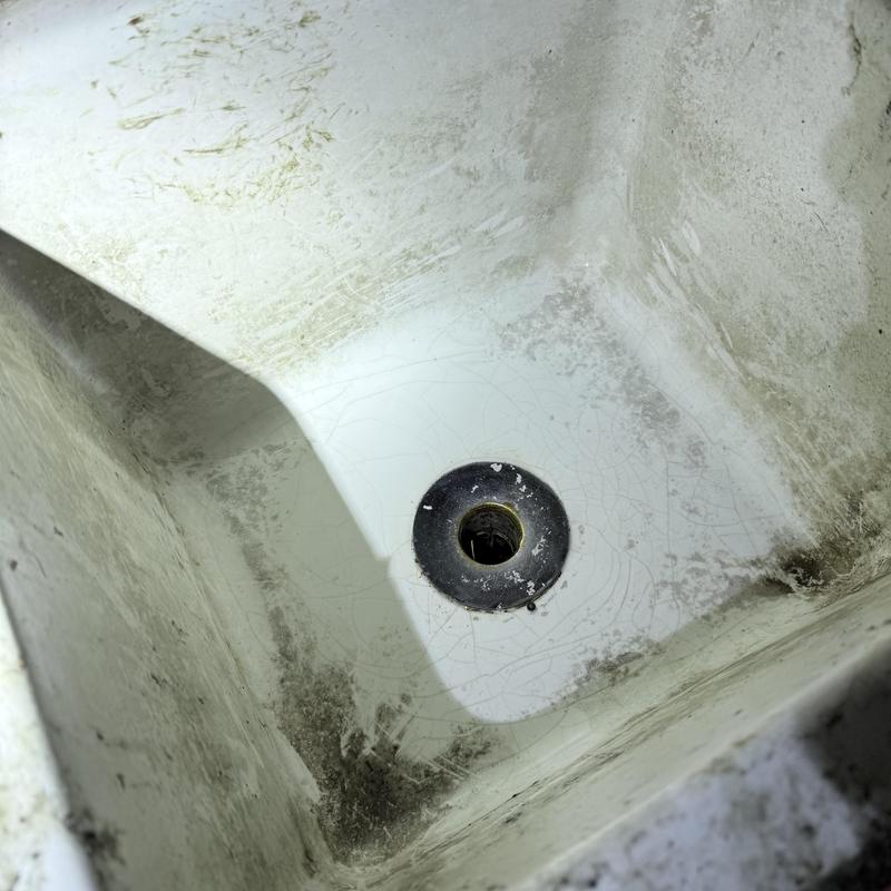 Sink drain with visible grime and buildup around edges Sink drain with visible grime and buildup around edges