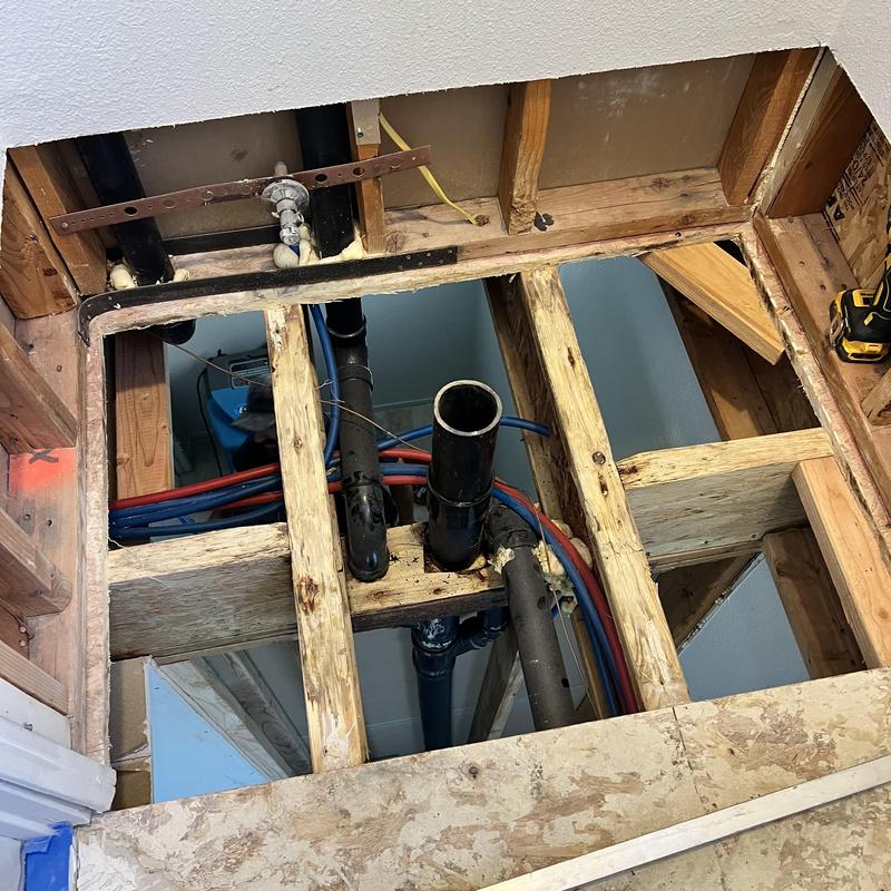 Toilet drain plumbing with subfloor installation in progress