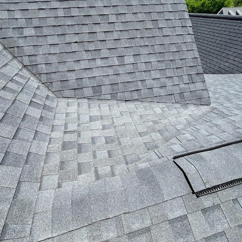 Asphalt shingle roof showing hail damage and ridge caps