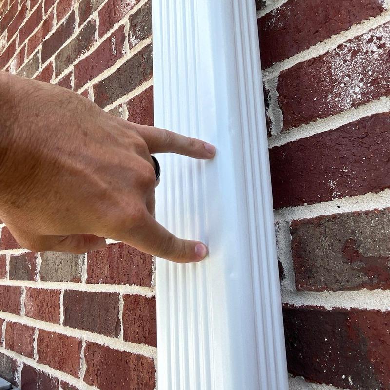 Downspout dent inspection on brick exterior wall