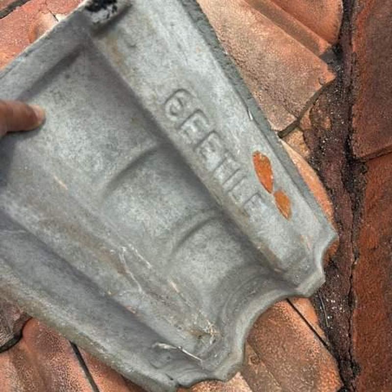Concrete tile roof with damaged and misaligned tiles